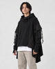 Model wearing the black layered sleeve hoodie with the hood down, stone trousers and white sneakers, three-quarter view