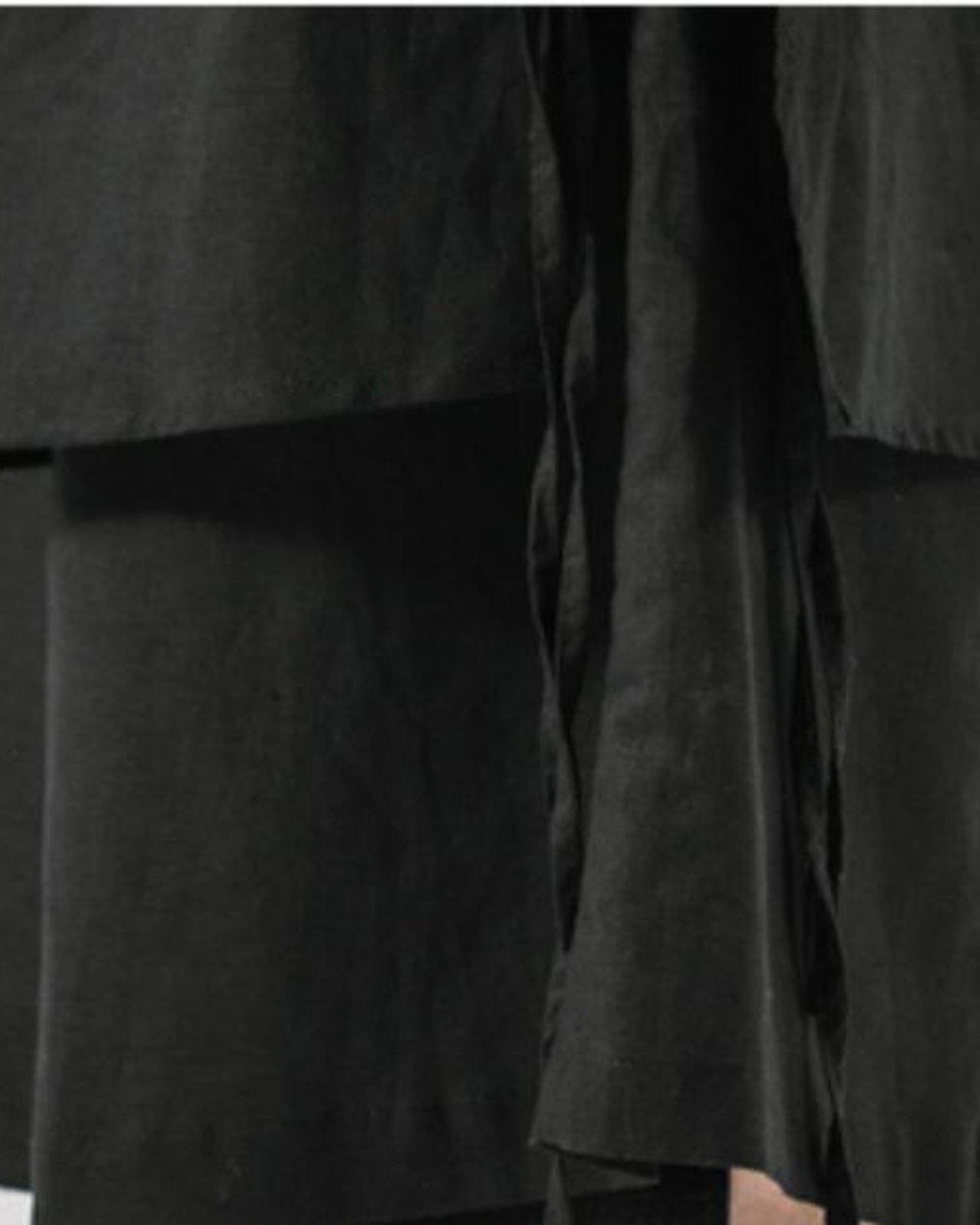 Close-up of the wrap panel hem over the wide legs and hanging ties