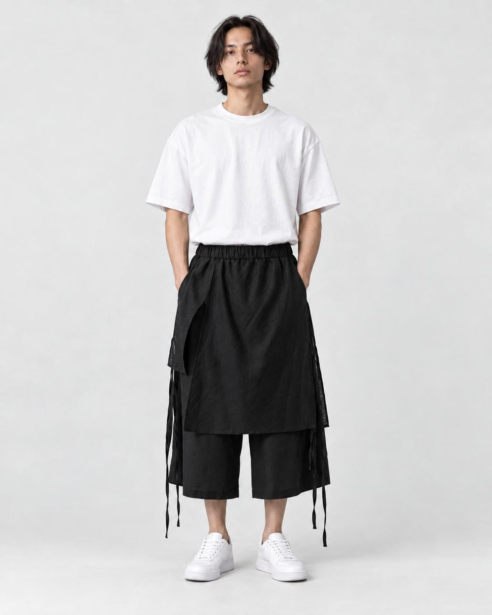 Model wearing the black layered wrap wide-leg pants with a white tee, front view