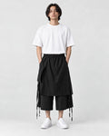 Model wearing the black layered wrap wide-leg pants with a white tee, front view