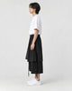 Model wearing the black layered pants, side view of the wrap panel and ties