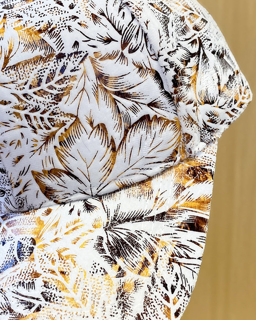 Close-up of the rust orange and gray leaf print on the white cap