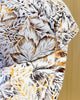 Close-up of the rust orange and gray leaf print on the white cap