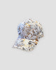White baseball cap printed with rust orange, tan and gray leaves, three-quarter view