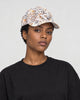 Model wearing the white leaf print baseball cap with a black tee, side view