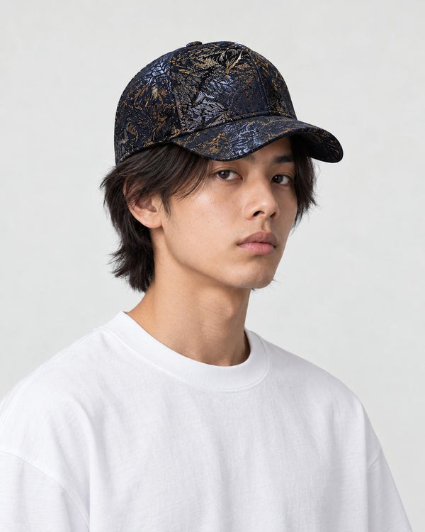 Model wearing the dark navy foil leaf print baseball cap with a white tee, three-quarter view