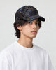 Model wearing the dark navy foil leaf print baseball cap with a white tee, three-quarter view