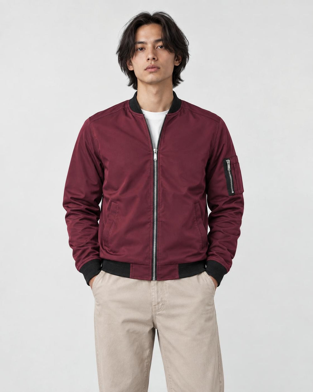 Model wearing the burgundy bomber jacket with stone trousers, front view
