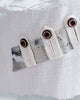 Close-up of the slanted row of buttoned tabs stitched over an ink-print strip