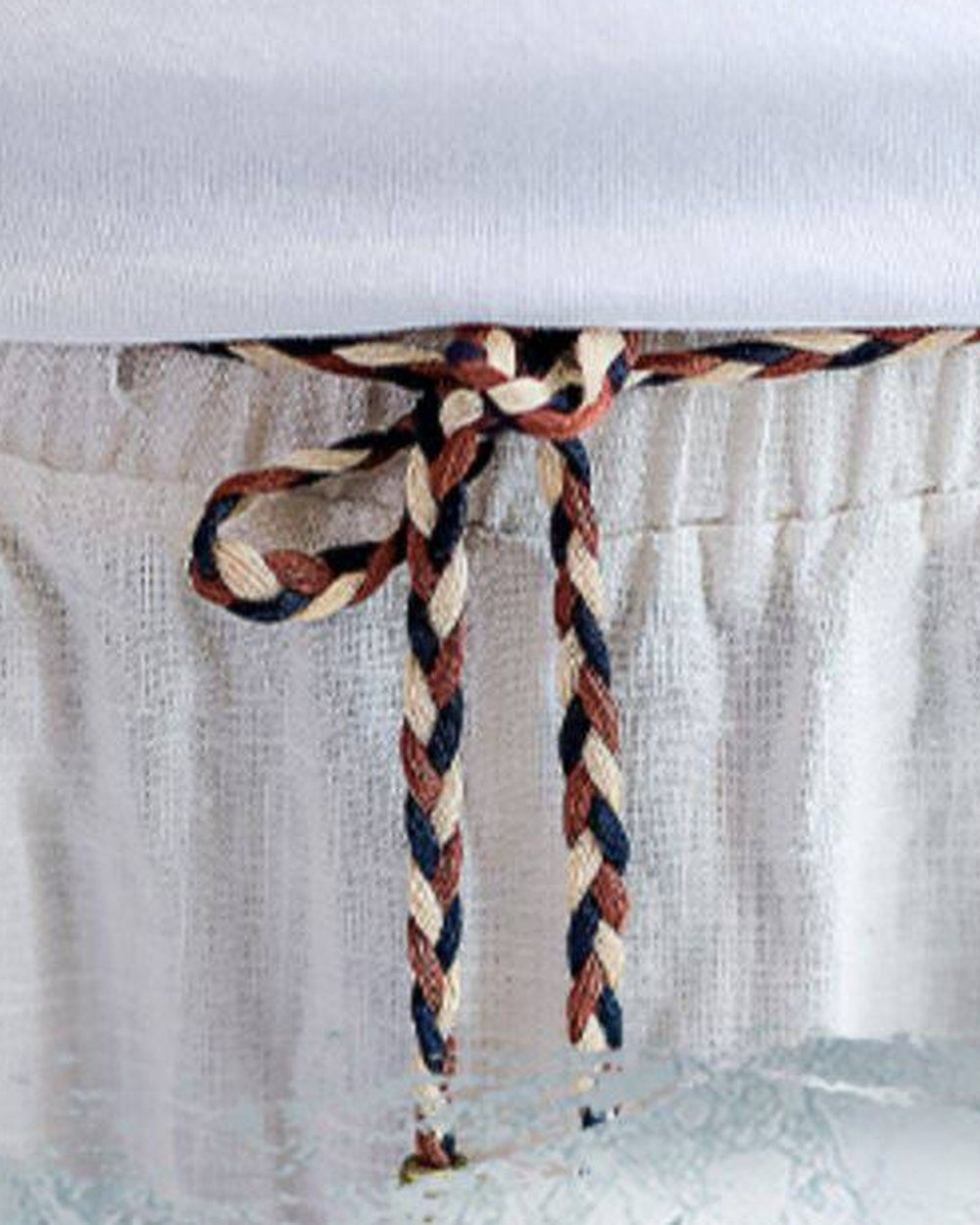 Close-up of the gathered elastic waist and the braided cord knotted at the front