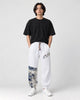 Model wearing the white linen-cotton jogger pants with a black tee and white sneakers, front view