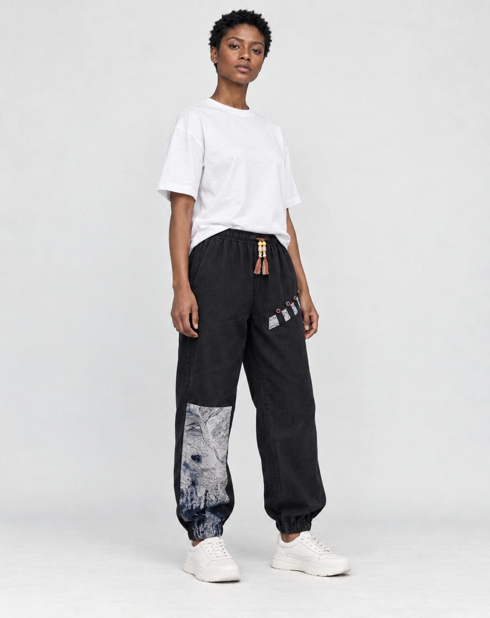 Model wearing the black linen-cotton jogger pants with a white tee and white sneakers, three-quarter view