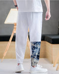 Back view of the white linen-cotton jogger pants showing the plain seat and the printed panel on the lower leg