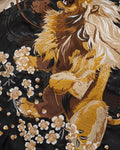 Close-up of the embroidered lion with its cream mane among blossoms
