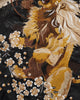 Close-up of the embroidered lion with its cream mane among blossoms