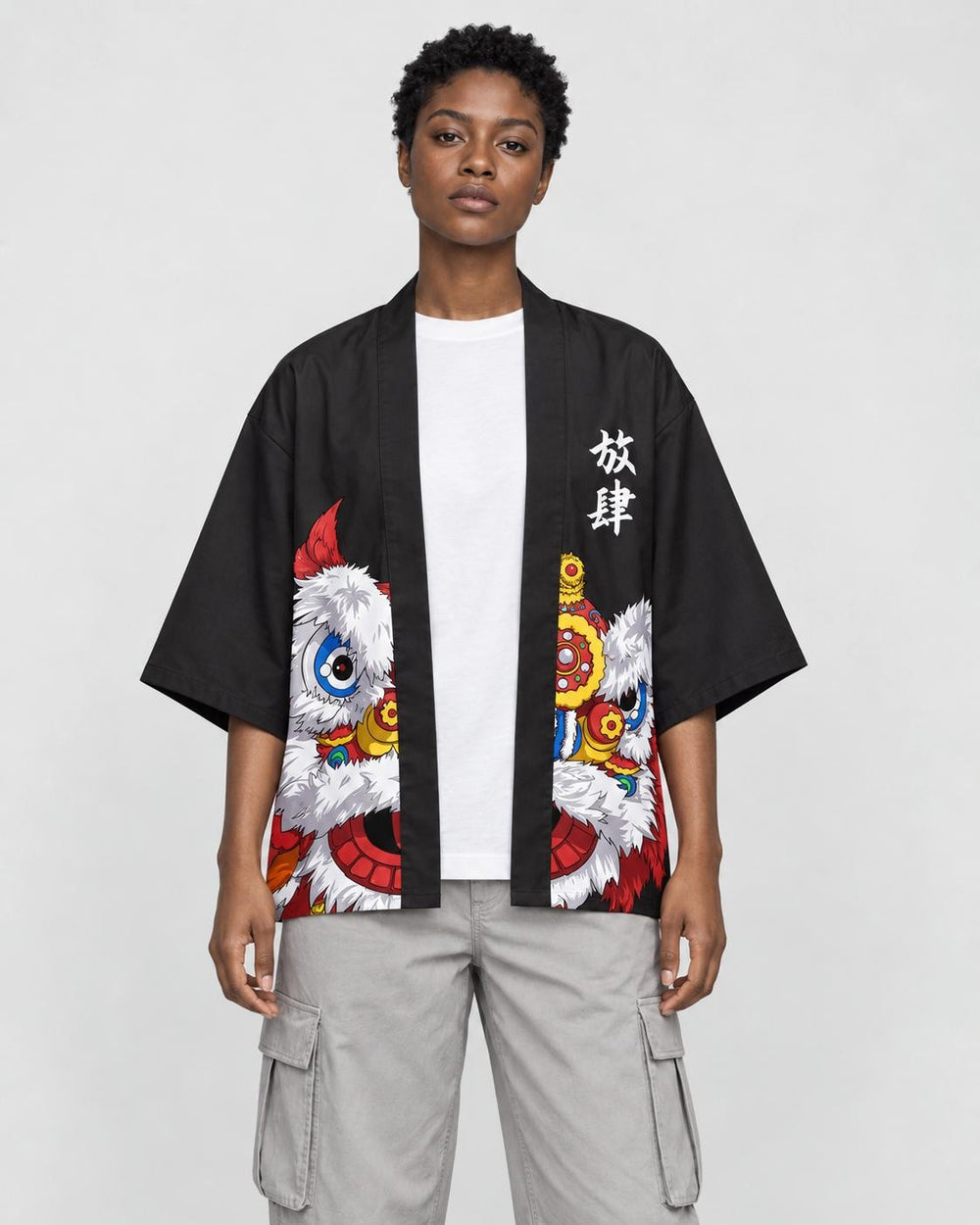 Model wearing the black lion dance haori cardigan open over a white tee and stone trousers, front view