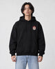 Model wearing the black hoodie with the small lion emblem on the chest, front view