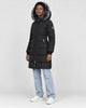 Model wearing the black puffer coat with a dark gray faux-fur hood, light-wash jeans and white sneakers, three-quarter view