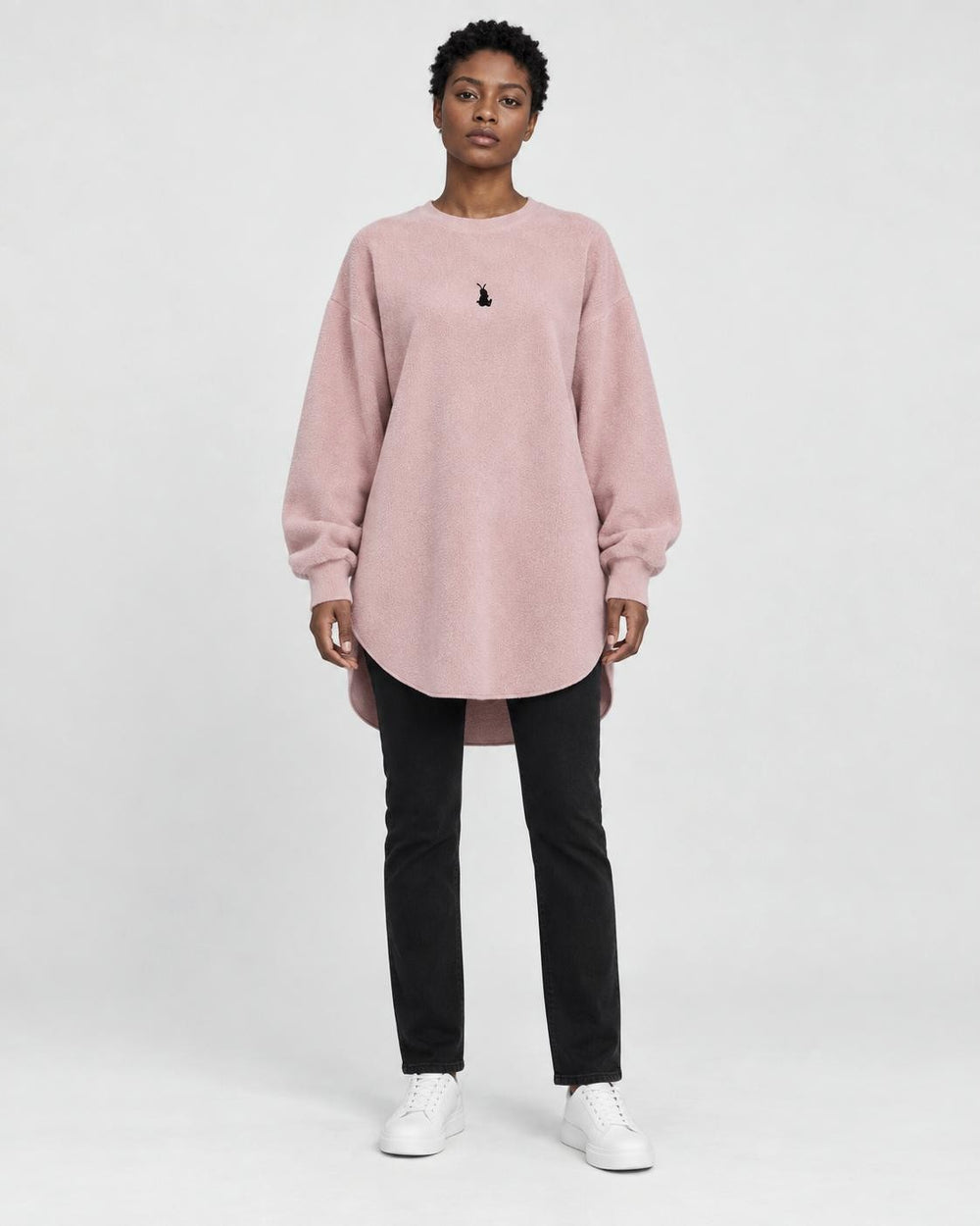 Model wearing the pink longline brushed pullover with slim black jeans, front view