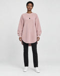 Model wearing the pink longline brushed pullover with slim black jeans, front view