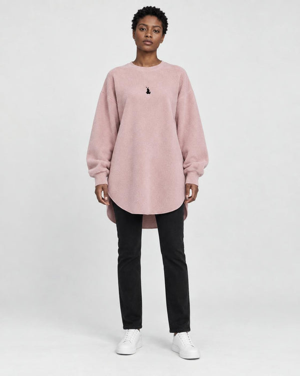 Model wearing the pink longline brushed pullover with slim black jeans, front view