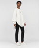 Model wearing the white longline brushed pullover, three-quarter view