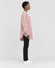 Model wearing the pink longline pullover, side view of the curved hem