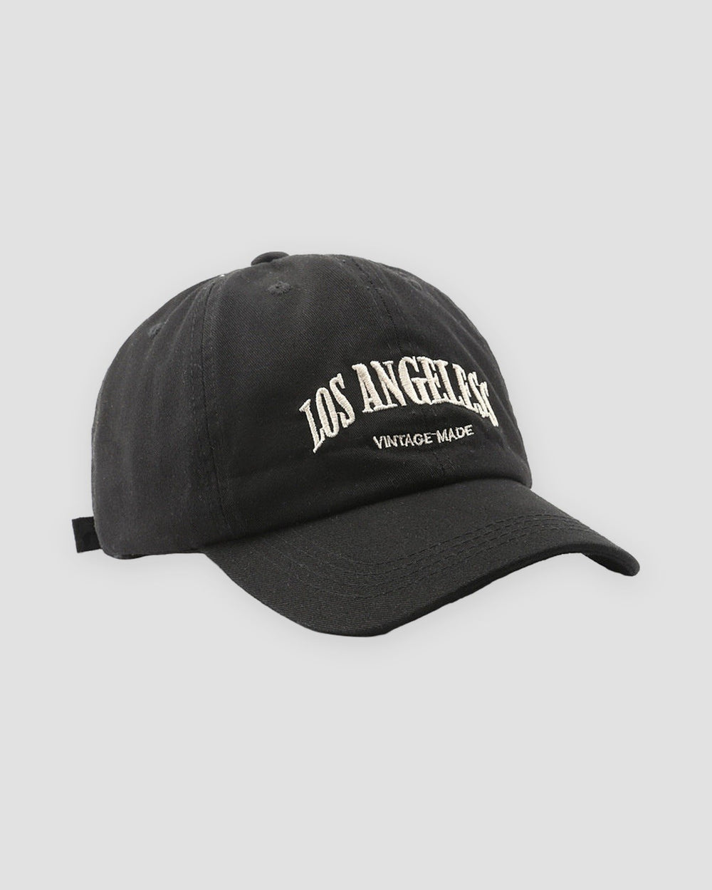 Black Los Angeles dad cap, three-quarter view, off-white arched lettering