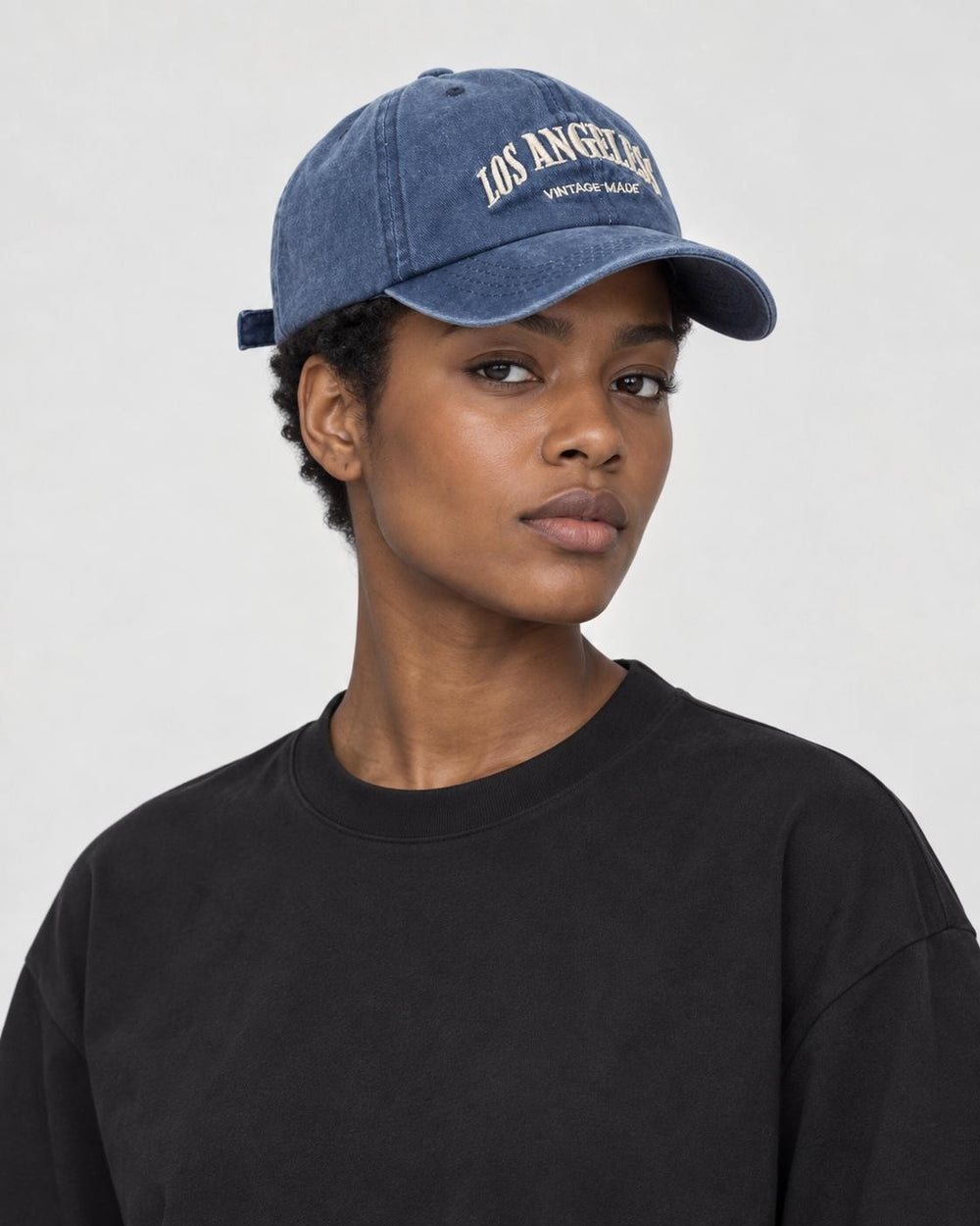 Model wearing the washed navy Los Angeles dad cap, three-quarter view
