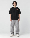 Model wearing the black daruma T-shirt with jeans, front view