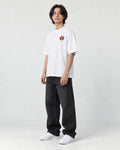 Model wearing the white daruma T-shirt, three-quarter view