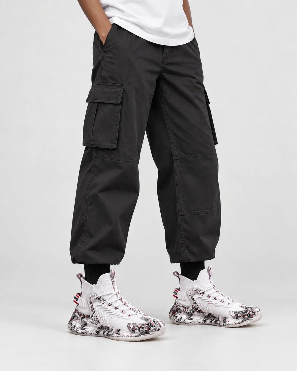 Model wearing the white marble print high-top sneakers with black cargo trousers, front view