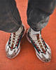 Beige marble print high-top sneakers worn on an orange floor, seen from above