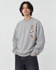 Model wearing the heather gray crewneck sweatshirt with three small space icons on the chest, with dark jeans