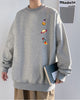 Heather gray crewneck sweatshirt with an astronaut, a ringed planet and a rocket printed in a column on the left chest