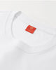 Close-up of the double-stitched collar and the small red woven label inside the neck of the white T-shirt