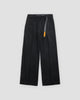 Black corduroy wide-leg pants with a webbing belt and an orange tag, flat view