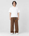 Model wearing the brown corduroy wide-leg pants with a white tee and white sneakers, front view