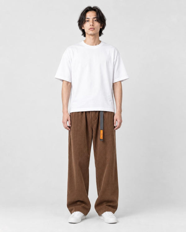 Model wearing the brown corduroy wide-leg pants with a white tee and white sneakers, front view