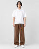 Model wearing the brown corduroy wide-leg pants with a white tee and white sneakers, front view