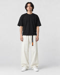 Model wearing the cream corduroy wide-leg pants with a black tee and white sneakers, front view