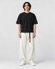 Model wearing the cream corduroy wide-leg pants with a black tee and white sneakers, front view