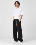 Model wearing the black corduroy wide-leg pants with a white tee and white sneakers, three-quarter view