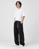 Model wearing the black corduroy wide-leg pants with a white tee and white sneakers, three-quarter view