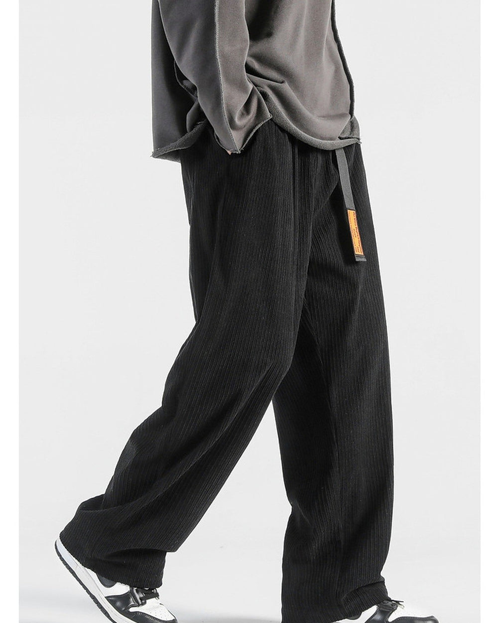 Black corduroy wide-leg pants in motion, showing the wide straight leg