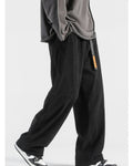 Black corduroy wide-leg pants in motion, showing the wide straight leg