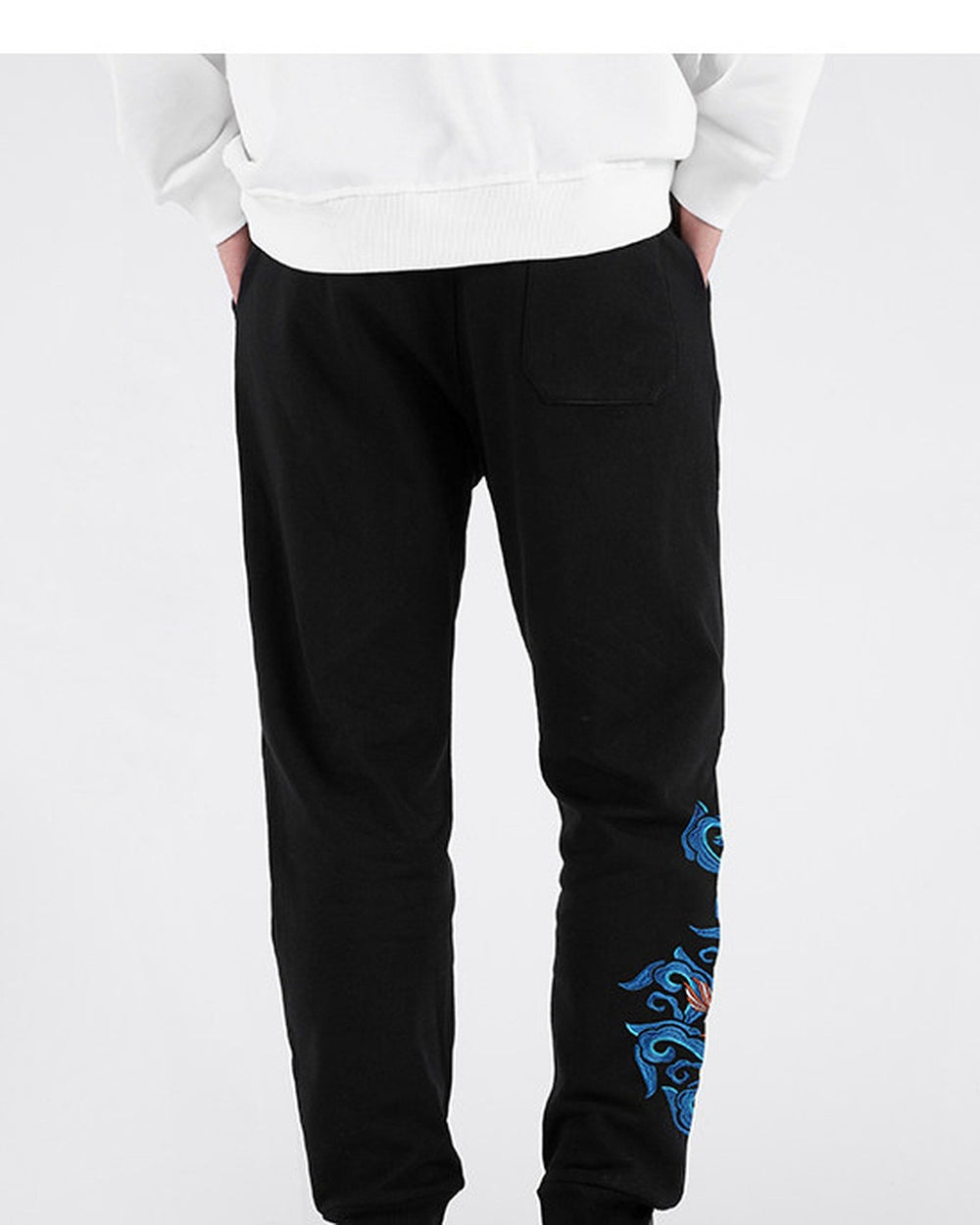 Back view of the black jogger pants with a patch pocket and the embroidery on one leg