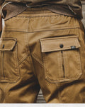 Close-up of the two flap back pockets with snap buttons on khaki jogger pants