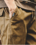 Close-up of the slanted side pocket and drawcord waist on khaki jogger pants