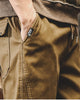 Close-up of the slanted side pocket and drawcord waist on khaki jogger pants